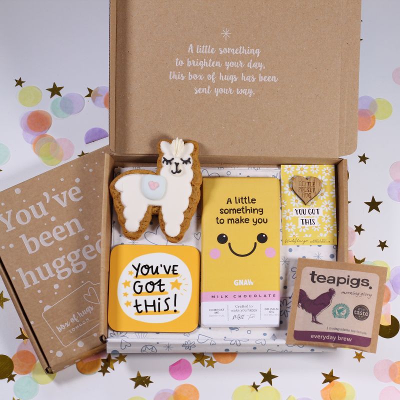 Gift box with cookies, chocolate bars, and a teapigs package on a colorful background