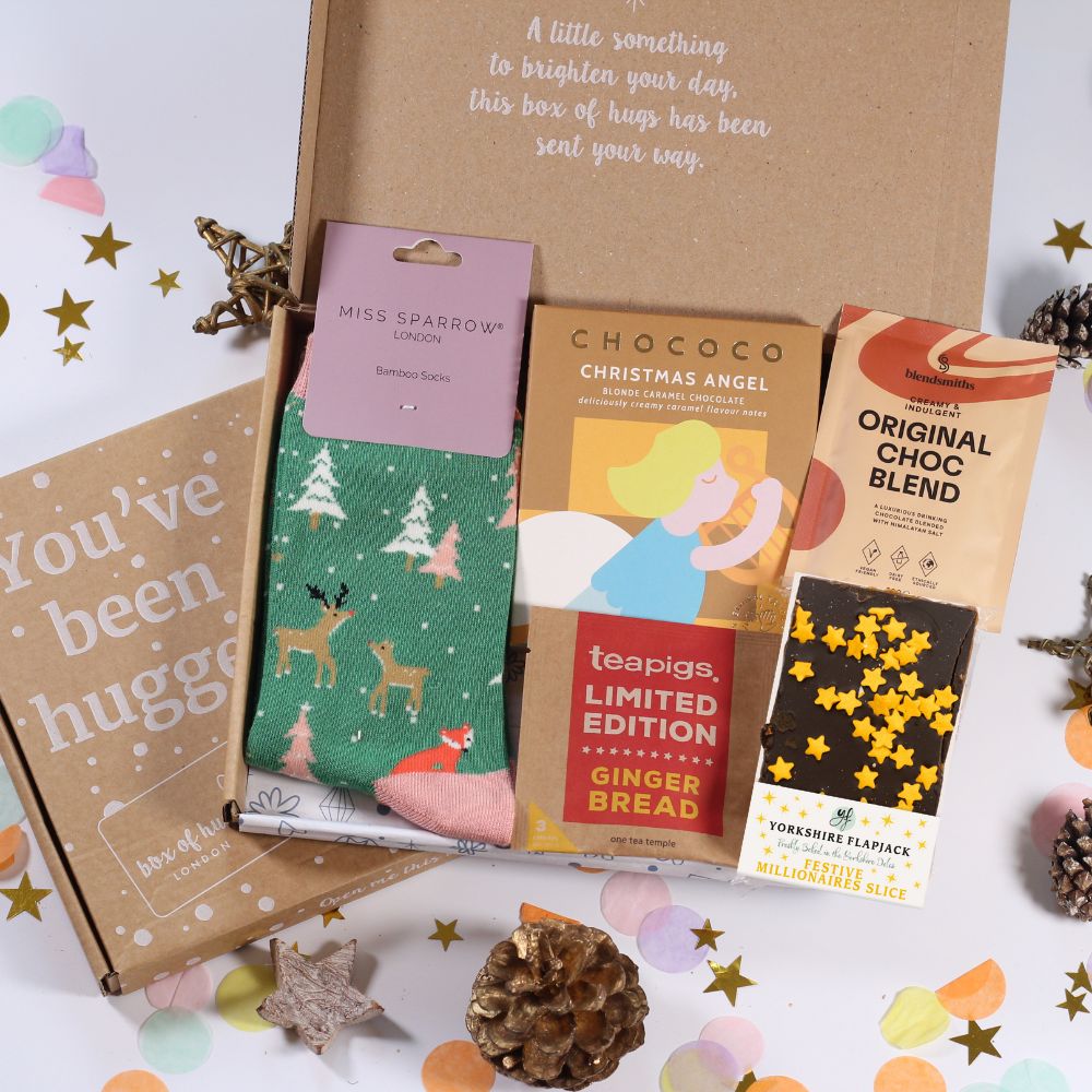 Letterbox Gift box with Christmas-themed items including Christmas socks, tea, and hot chocolate, chocolate bar and festive flapjack.