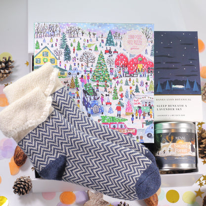 Christmas-themed gift box with cosy socks, Christmas Jigsaw, lavender bath bar and St Eval Sacred Forest tin candle.