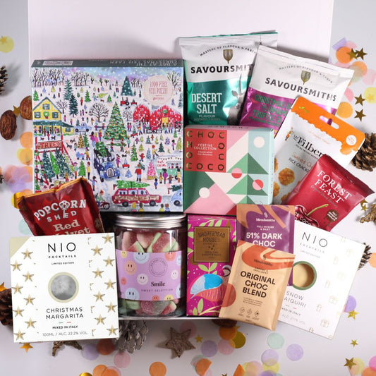 Christmas Gift hamper with Assorted festive food products, including sweets, festive chocolates, crisps, chocolate cherries, hot chocolate, shortbread, cocktails, popcorn and a festive jigsaw.