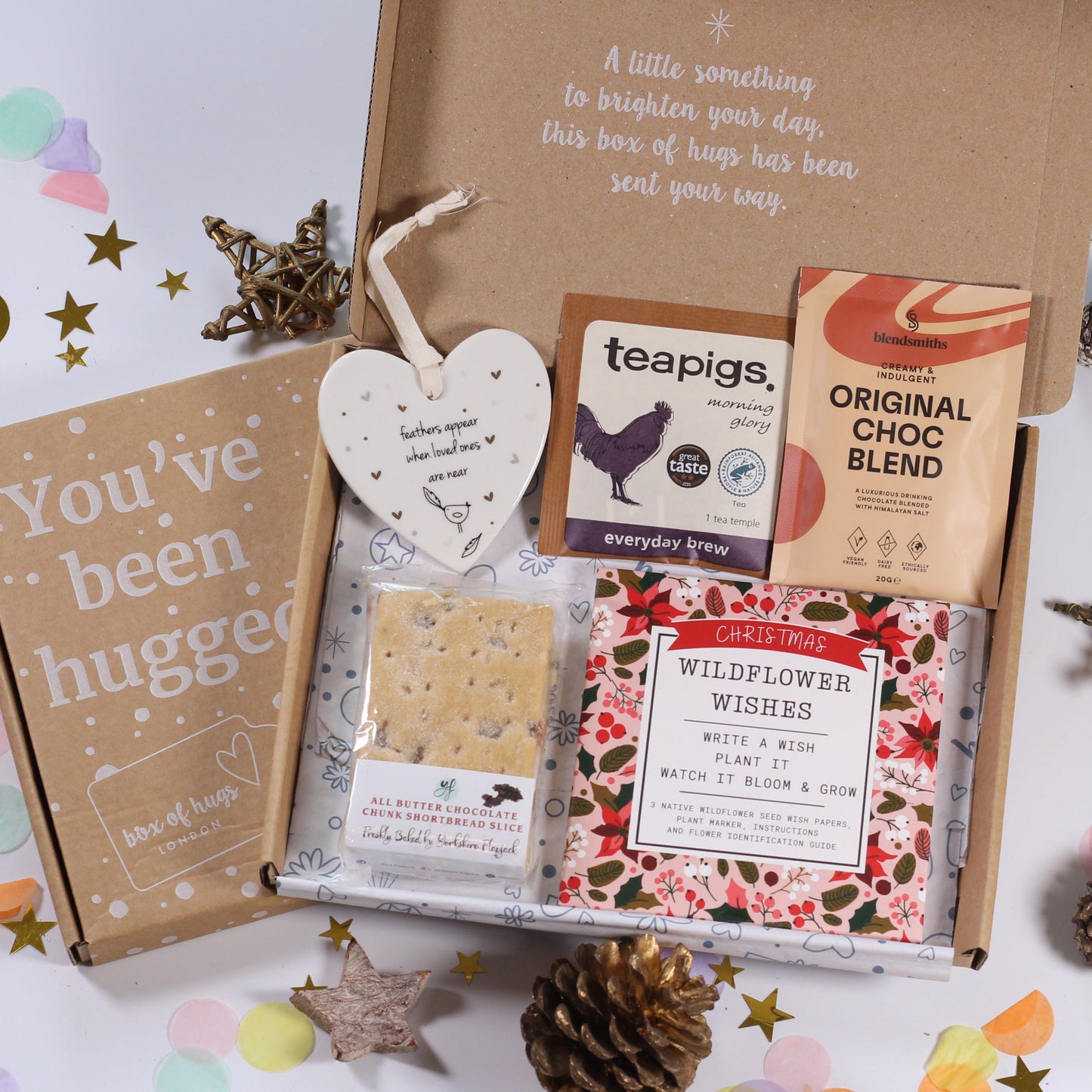 Letterbox gift box with tea, hot chocolate  cards, feathers appear heart ceramic plaque, chocolate chunk shortbread and wildflower wishes write a wish and plant it and let it grow.