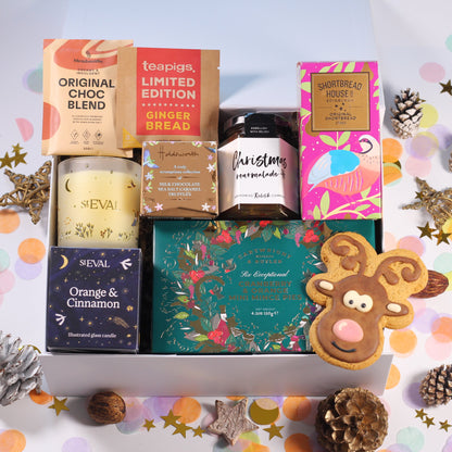 Christmas gift box with St eval orange and cinnamon candle, mince pies, Christmas marmalade, hot chocolate, shortbread, chocolate caramels, and iced gingerbread biscuit.