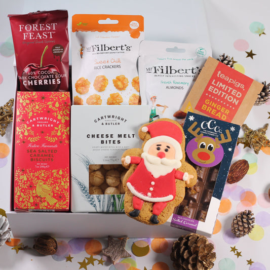 Christmas gift box with assorted Christmas-themed snacks including filberts chilli crackers, French rosemary almonds, chocolate cherries, gouda melts, chocolate bar and sea salted and caramel biscuits.