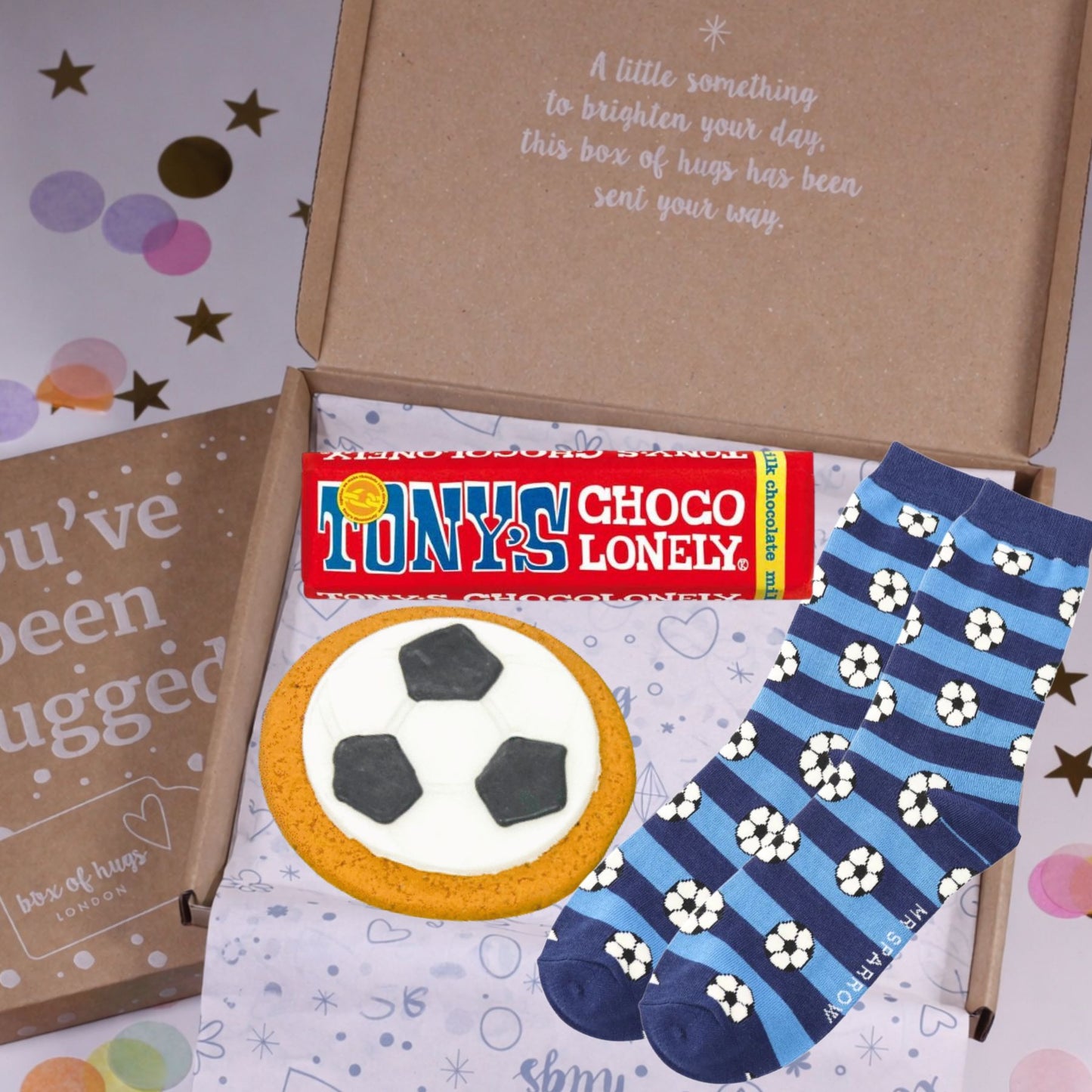Box of 'hugs' with Tony's Choco Lonely, a cookie, and a pair of socks on a colorful background.