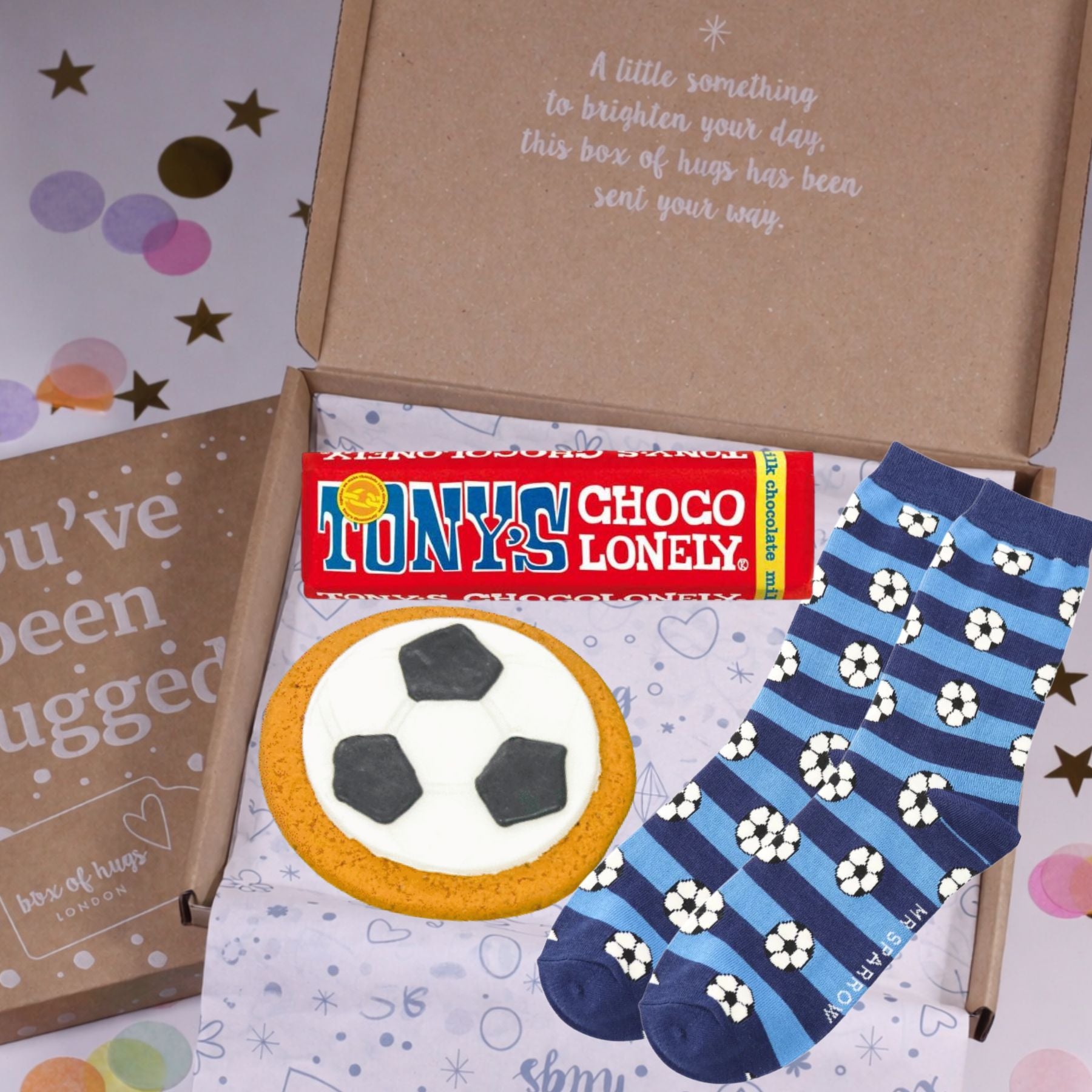 Box of 'hugs' with Tony's Choco Lonely, a cookie, and a pair of socks on a colorful background.