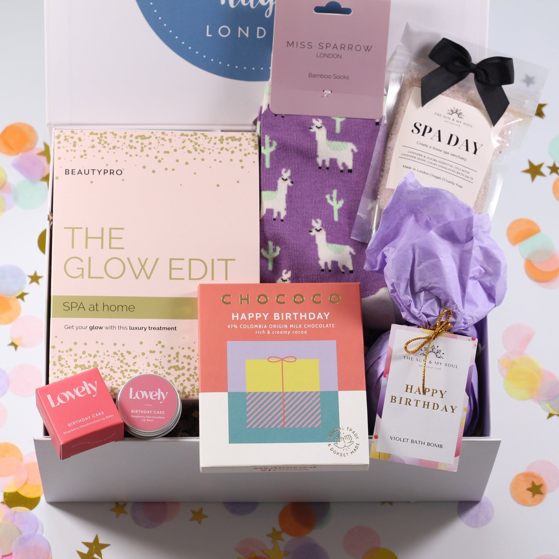 Gift box with various items on a white background with confetti