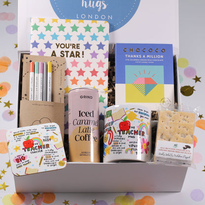 Gift box with stationery items and a can of coffee on a colorful confetti background