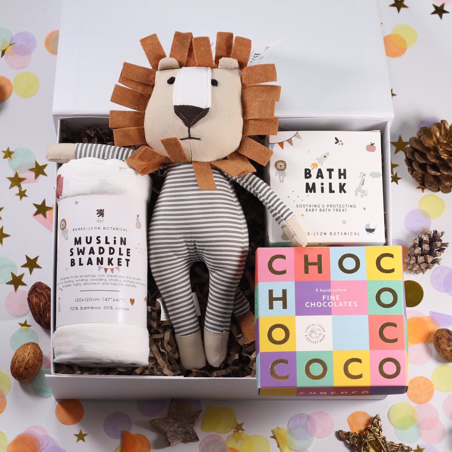 Gift set with lion toy, swaddle blanket, and bath milk and fine chocolates.