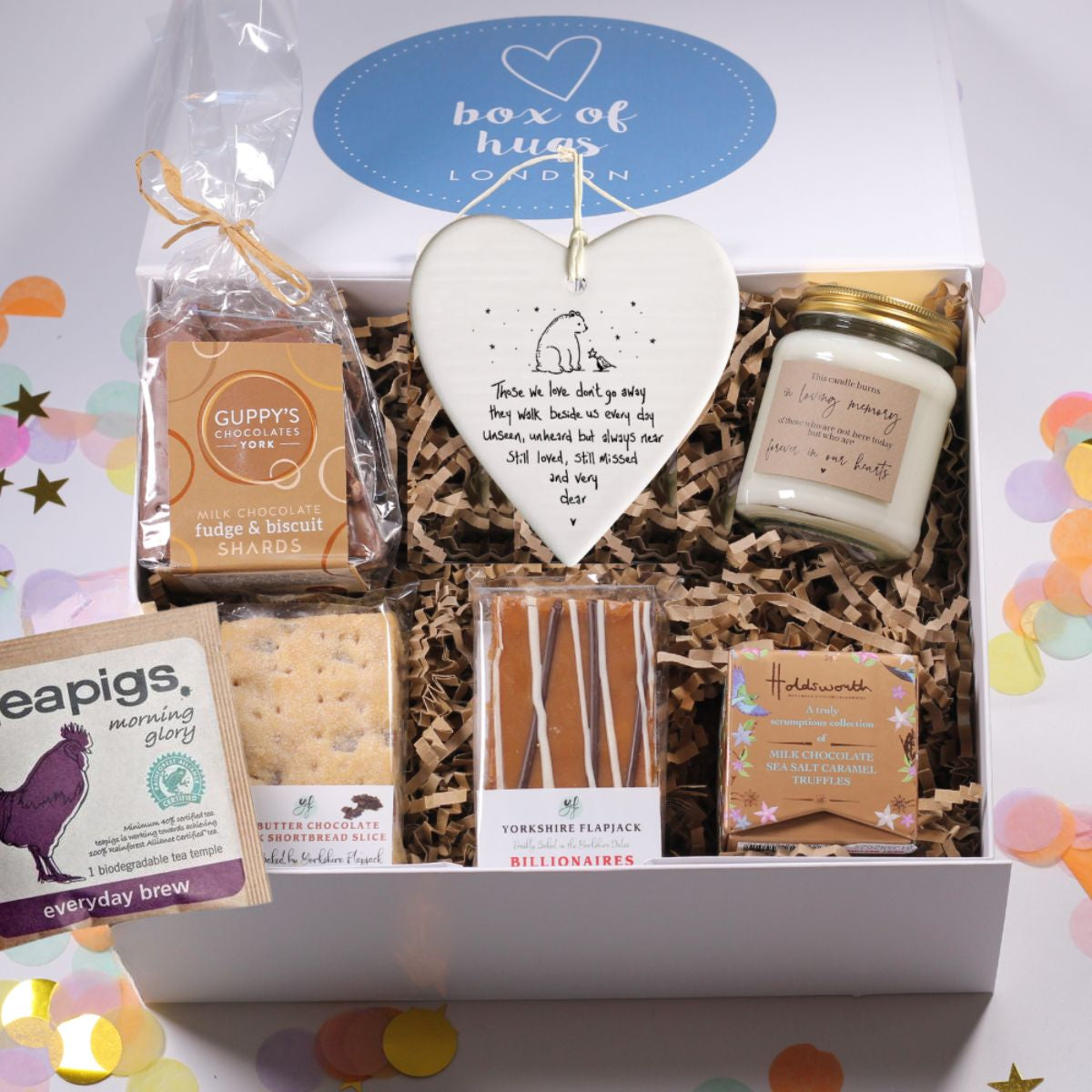 Gift box from Box of Hugs London with various items including a 'in loving memory candle' a heartfelt bereavement plaque and chocolates and flapjack and shortbread.