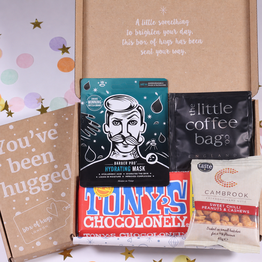 A curated gift box set from 'A little of everything' featuring a Barbie-themed hydrating mask, a black coffee bag, a red chocolate bar, and a bag of Cambridge peanuts, arranged inside an open kraft cardboard box.