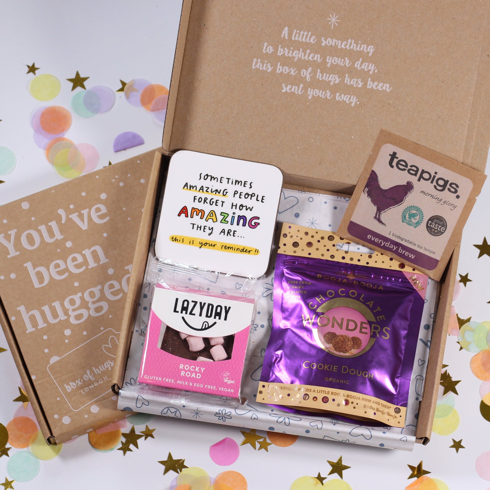Letterbox care package box with vegan treats, tea and a colourful coaster with uplifting quote.
