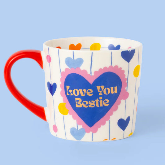 Mug with heart design and 'Love You Bestie' text on a blue background