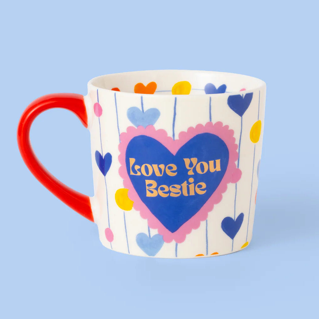 Mug with heart design and 'Love You Bestie' text on a blue background