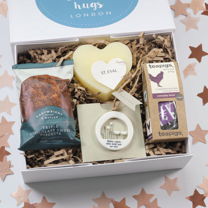 A white keepsake magnetic box with a robin bereavement decoration, a mini heart candle, triple chock chunk biscuits, and tea.