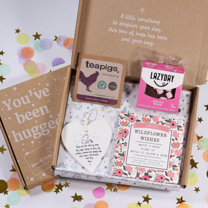letterbox care package with various items including a tea, gluten and dairy free rocky road, a bereavement heart ceramic sign and wildflower wishes - write a wish and plant it and watch it bloom.