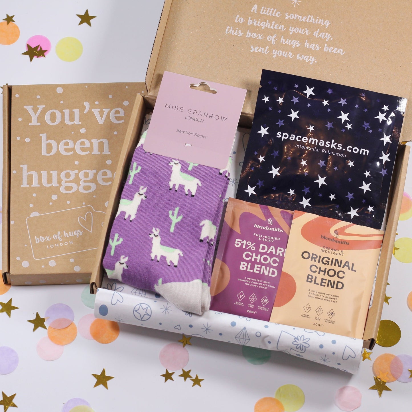 A letterbox gift box containing a pair of socks, hot chocolate and a self heating eye mask. 