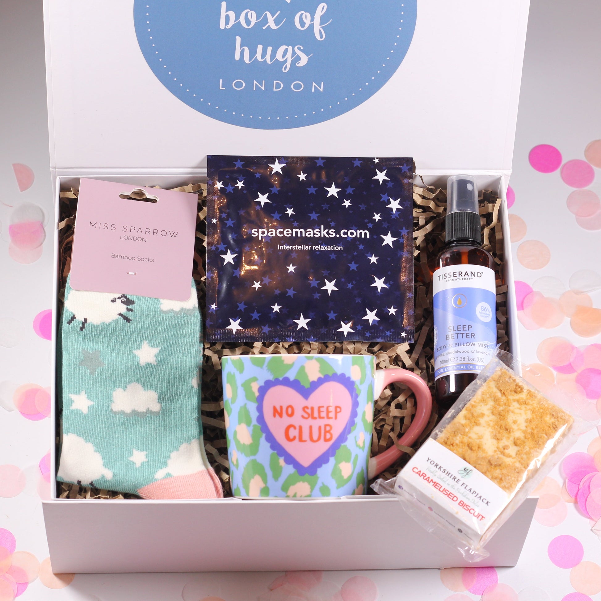 Gift box from 'box of hugs London' with various items including sheep socks, a no sleep mug, sleep spray, a sleep mask and flapjack.