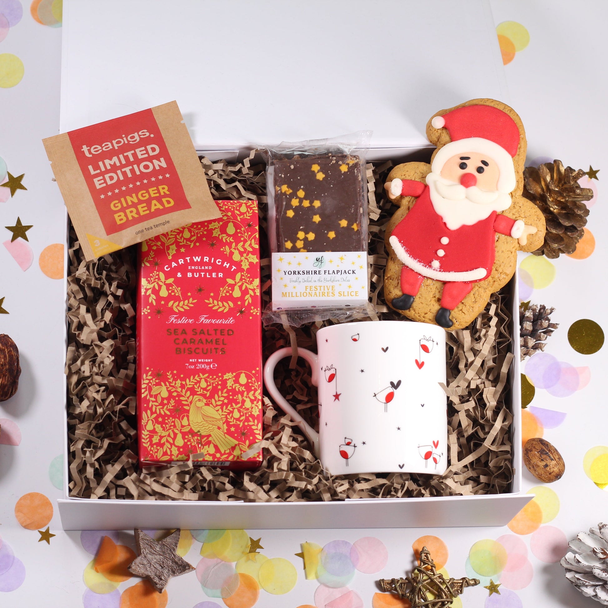 Christmas Gift box with tea, sea salted caramel biscuits, robin mug, festive flapjack  and an iced Santa gingerbread biscuit.