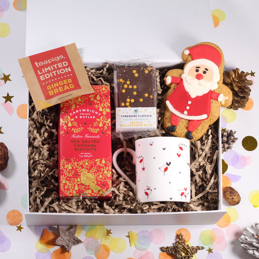 Christmas Gift box with tea, sea salted caramel biscuits, robin mug, festive flapjack  and an iced Santa gingerbread biscuit.