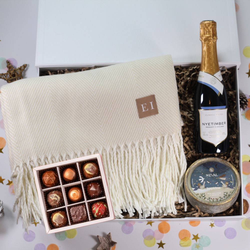 Luxury gift hamper with cosy blanket, beautiful St Eval Candle, English sparkling wine and festive chocolates. 