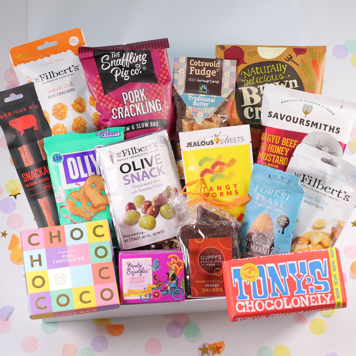 Assorted snack boxes and packages neatly arranged inside a white keepsake magnetic box, with colorful branding and packaging visible.