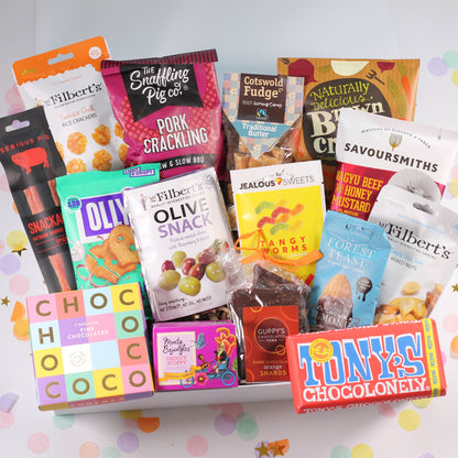 Assorted snack boxes and packages neatly arranged inside a white keepsake magnetic box, with colorful branding and packaging visible.