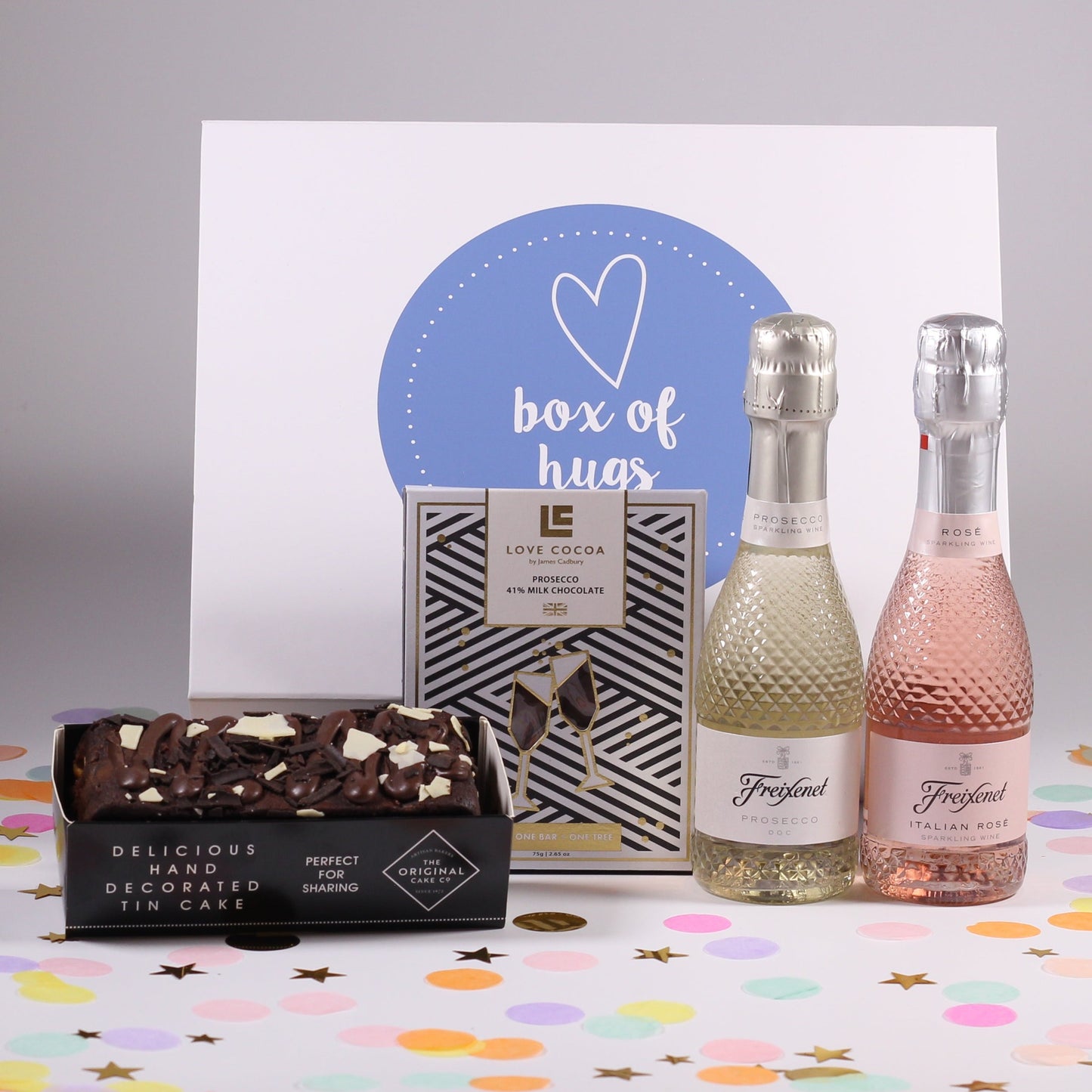 A gift box including two bottles of sparkling prosecco, a chocolate truffle cake and a bar of chocolate.